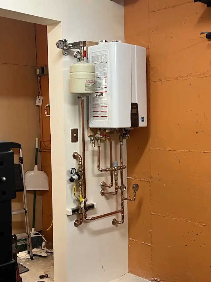 Plumbing technician inspecting water heater connections in West Columbia